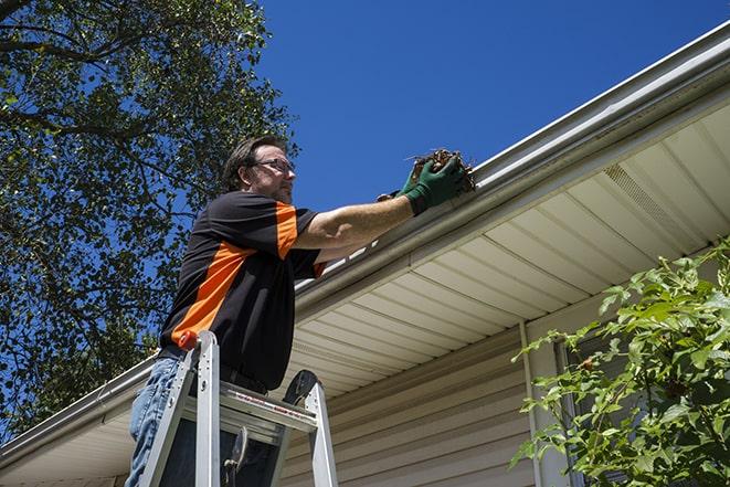 a professional repairing a leaking gutter to prevent water damage in Buellton, CA